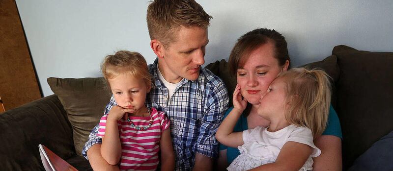 Alex and Heidi Jensen read to their daughters, Charlotte and Olivia, at home in Provo.