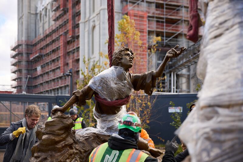 Sculptor Michael Hall helps place the First Vision statue on Temple Square on Wednesday, Nov. 6, 2024.
