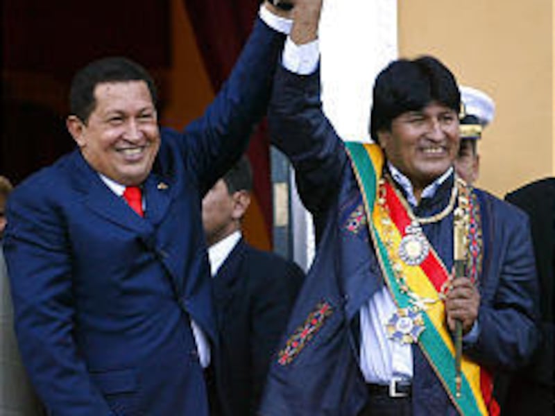 Bolivian President Evo Morales, right, joins Venezuela's Hugo Chavez as he waves to his people in La Paz Sunday.