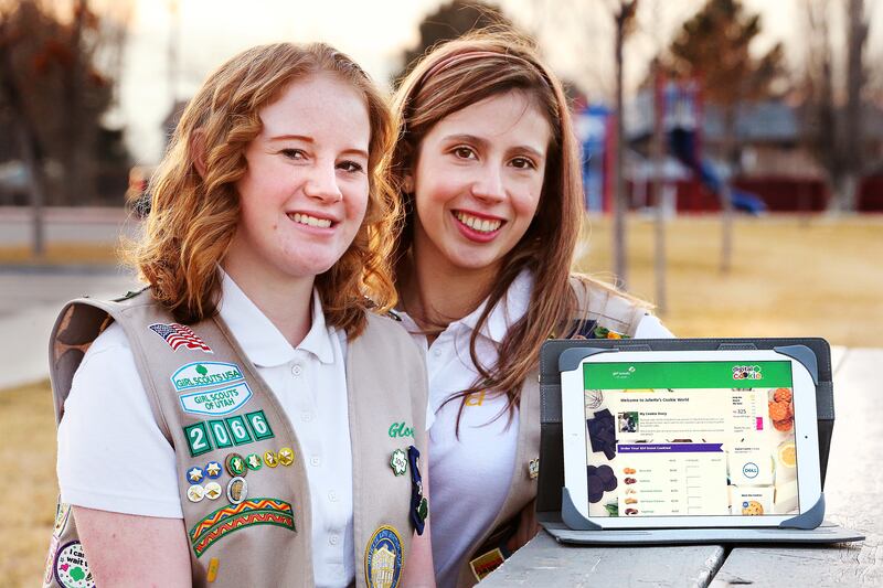 Girl Scouts Gloria Heslop and Kelly Lopez pose with a photo of their digital cookie site on Wednesday, Jan. 17, 2018.