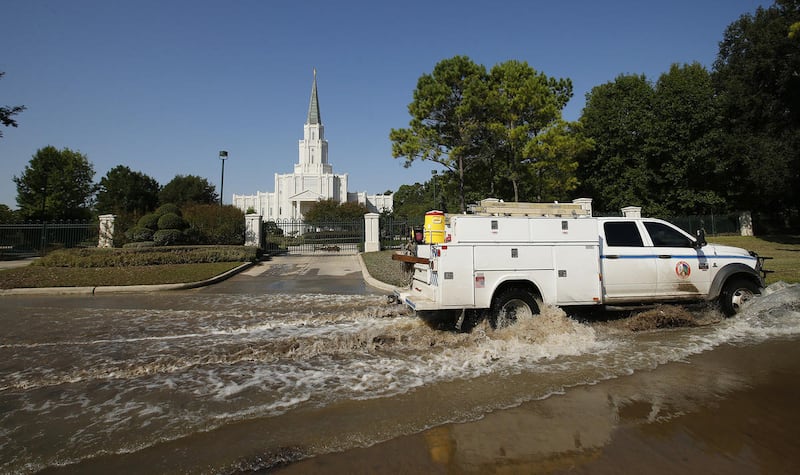 A utility truck drives through water near the LDS Houston Texas Temple after Tropical Storm Harvey in Spring, Texas on Thursday, Aug. 31, 2017.
