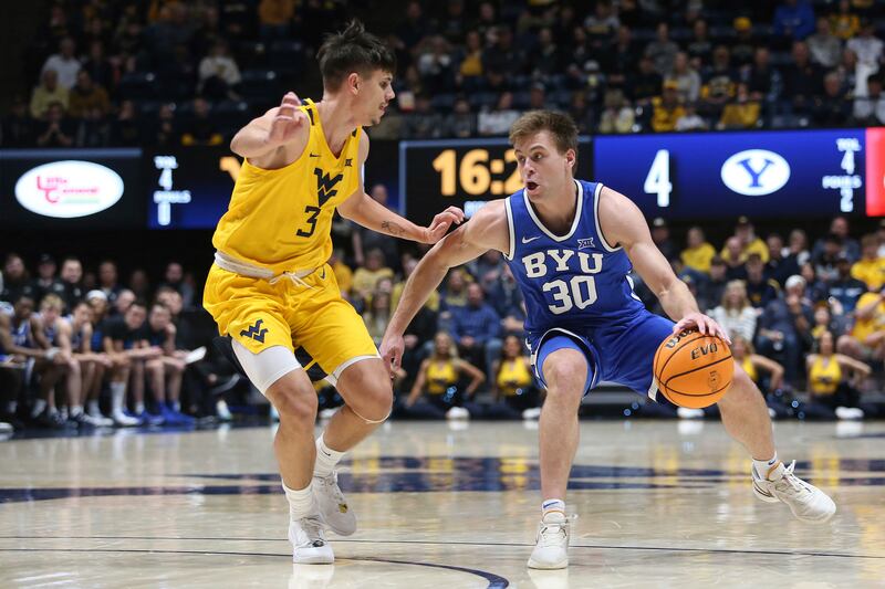 BYU guard Dallin Hall (30) is defended by West Virginia guard Kerr Kriisa (3) during the first half of an NCAA college basketball game Saturday, Feb. 3, 2024, in Morgantown, W.Va. (AP Photo/Kathleen Batten)