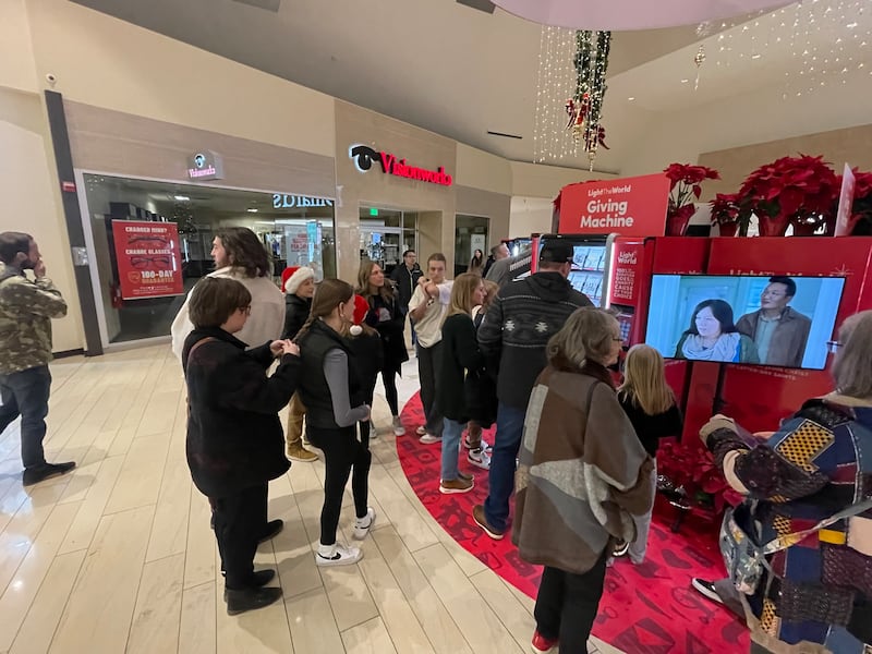 Crowds line up to make donations at the Light the World Giving Machines at University Place in Orem, Utah, on Dec. 23, 2023.