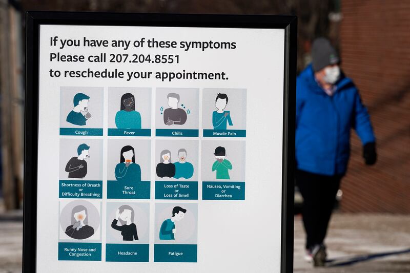 A sign lists symptoms for COVID-19 in Maine.