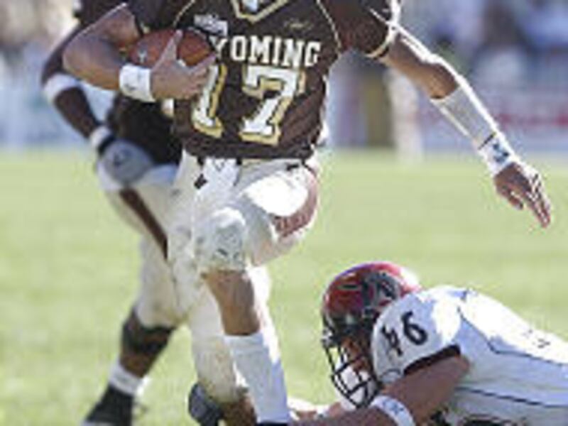 Wyoming quarterback Corey Bramlet (17) runs past the tackle of San Diego State's Blake Lobel during the Cowboys' win Saturday.