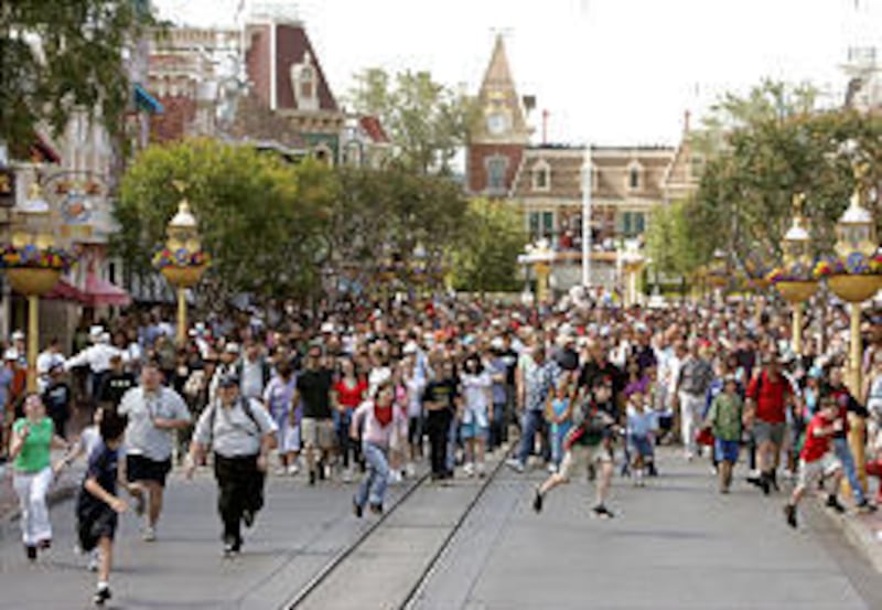 Visitors to Disneyland rush into the park as it opens for the day in Anaheim, Calif., on Tuesday morning.
