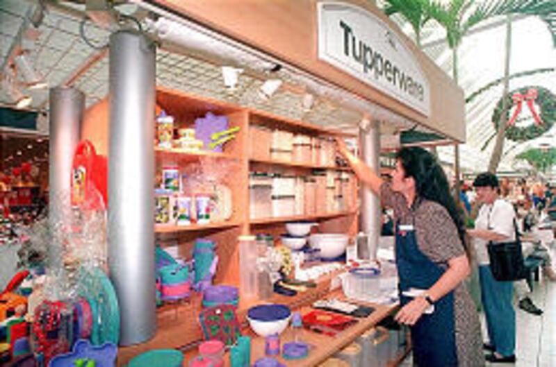 Gina Andrews arranges Tupperware products at kiosk in mall in Ocoee, Fla. The products are specifically made for use in the microwave.