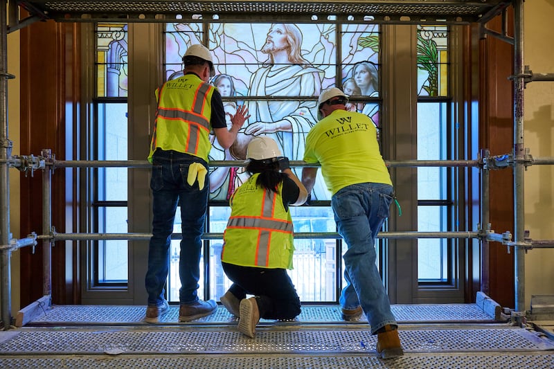 Crews meticulously place panels of art glass in the north entrance buildings on Temple Square in Salt Lake City on Wednesday, March 11, 2026.