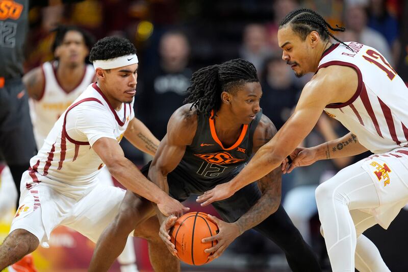 Iowa State’s Tamin Lipsey, left, and Robert Jones, right, try to steal ball from Oklahoma State’s Javon Small, Jan. 13, 2024.