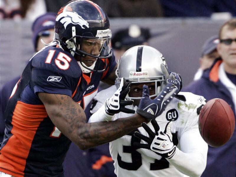 Denver Broncos receiver Brandon Marshall is defended by Raiders cornerback Chris Johnson in Oakland's upset victory on Sunday.