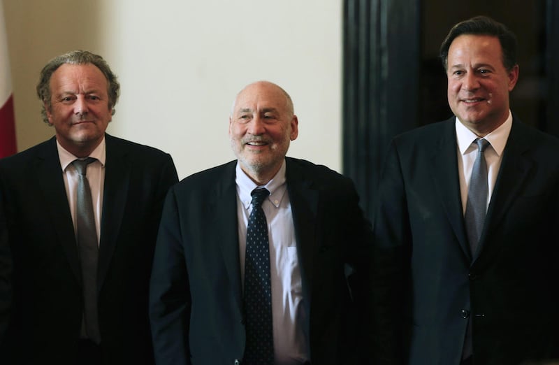 Panama's President Juan Carlos Varela, right, poses for a photo with Nobel economics laureate Joseph Stiglitz, center, and Mark Pieth, a professor of criminal law and criminology at the University of Basel, in Panama City, Friday, April 29, 2016. Incorrec