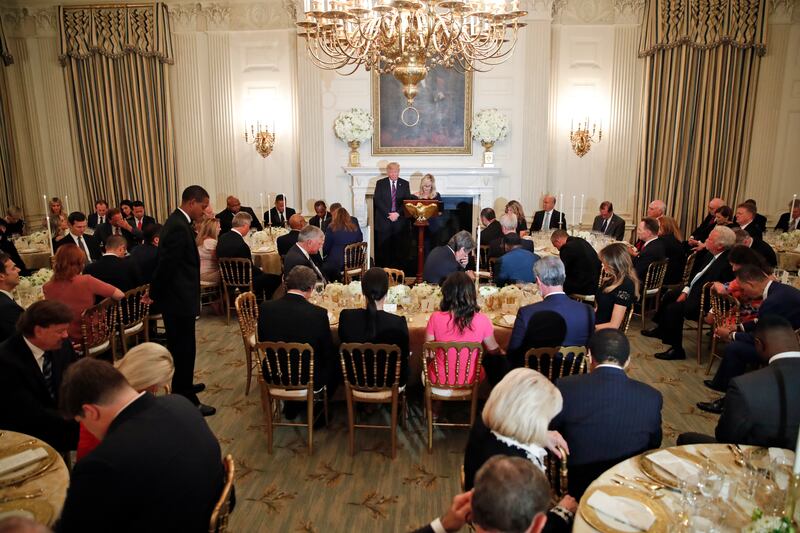 Pastor Paula White leads the room in prayer during a dinner for evangelical leaders in the State Dining Room of the White House, Monday, Aug. 27, 2018, in Washington.