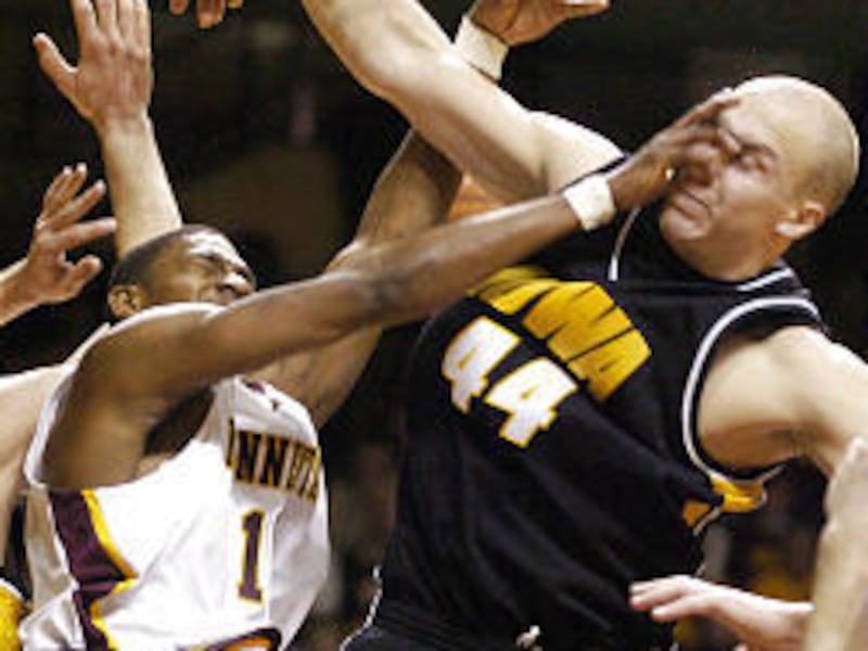 Iowa's Greg Brunner, right, receives a shot to the face from Minnesota's Vincent Grier during the Gophers' upset victory over the Hawkeyes on Saturday.