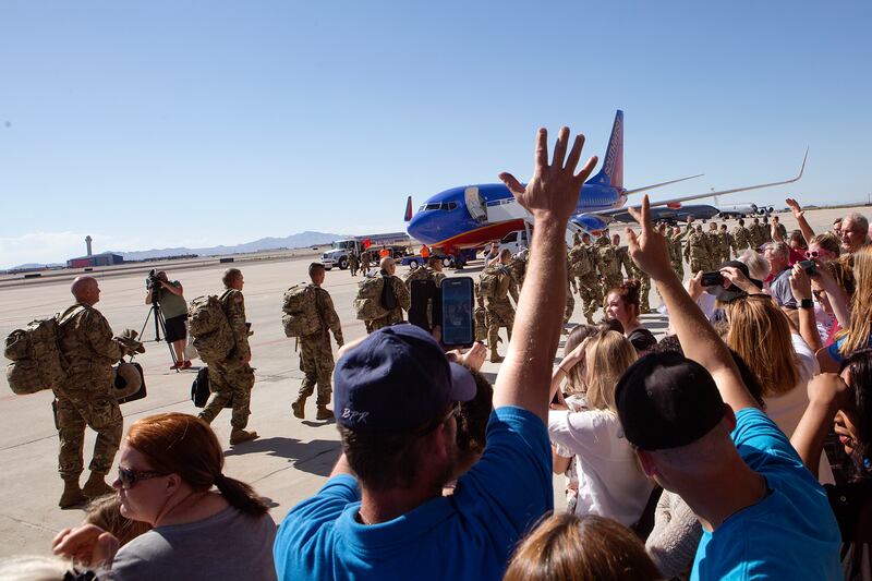 Friends and family wave goodbye to Utah National Guard soldiers being deployed to the Middle East at the Roland R. Wright Air National Guard Base in Salt Lake City on Monday, June 4, 2018.