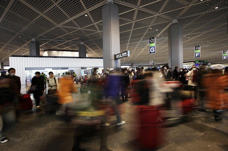 Chinese people are guided to airline counters at Narita airport, near Tokyo, Thursday, March 17, 2011. The airport was crowded with evacuees and regular passengers Thursday following advisories from foreign governments recommending citizens leave the coun