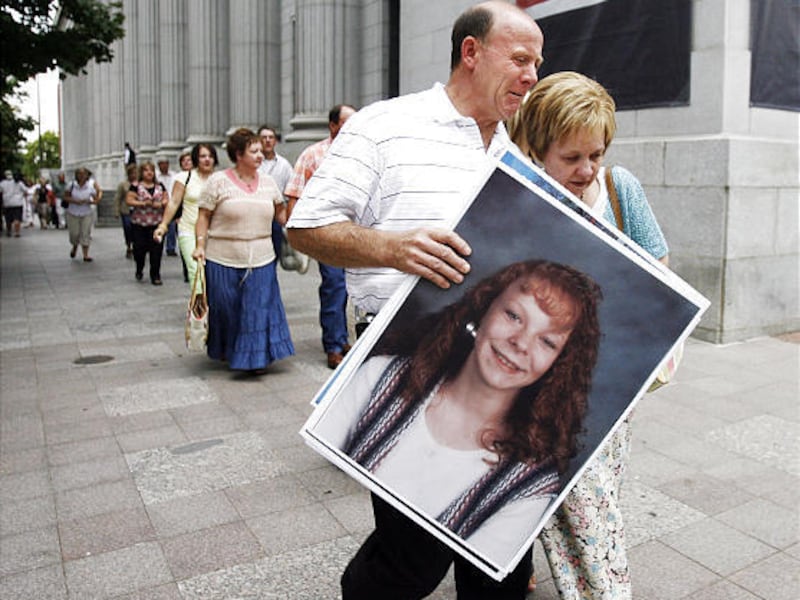 Richard and Tamara Davis show emotion as they leave court carrying a photo of their missing daughter Kiplyn following a trial where Timmy Olsen was found guilty on all counts in federal court in Salt Lake City. Olsen and two other men are in jail in conne
