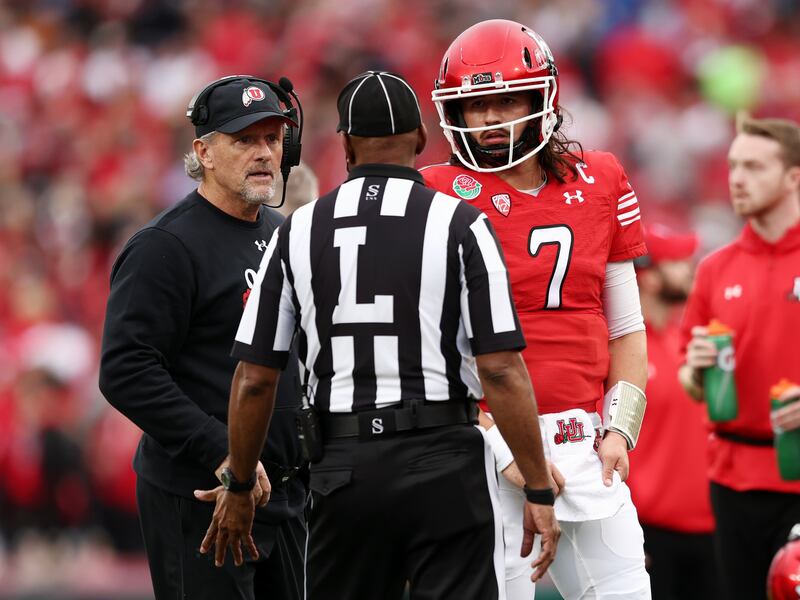 Utah head coach Kyle Whittingham and QB Cam Rising listen to an official as Utah and Penn State play in the 2023 Rose Bowl.
