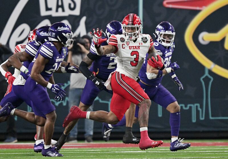 Utah Utes running back Ja’Quinden Jackson looks to stiff arm Northwestern Wildcats defensive back Rod Heard II