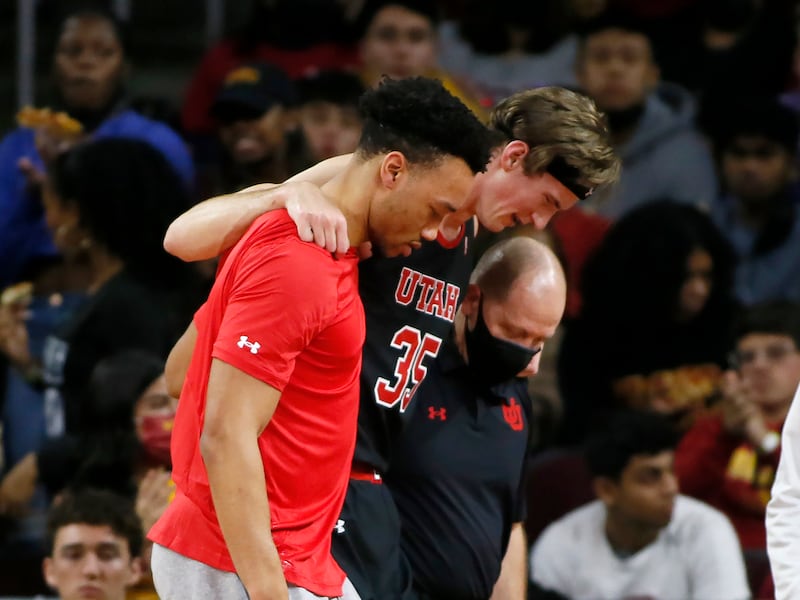 Utah center Branden Carlson (35) is helped off the court during the first half of the team’s NCAA college basketball game against Southern California.
