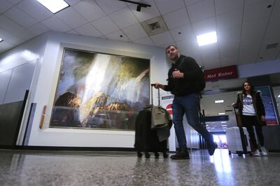 Travelers walk past “Desert Storm” by Doug Snow in terminal 2 at the Salt Lake City International Airport in Salt Lake City on Thursday, April 4, 2019. Artists are being sought to create installations for the new terminal set to open in 2020.