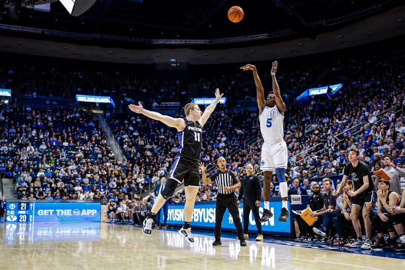 BYU’s Gideon George, right, shoots a 3-pointer during the Cougars’ 71-58 win over Portland at the Marriott Center in Provo on Saturday, Dec. 31, 2022.