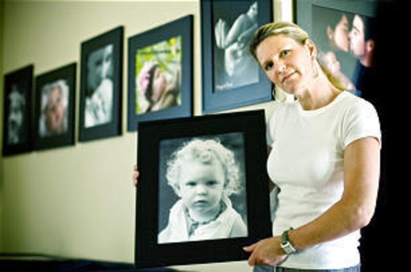 Margaret Boyd holds one of her photographs of babies. Her husband died when their baby was only 4 1/2 months old.