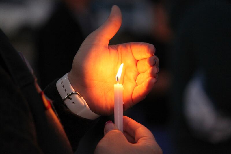A community member holds a candle during a prayer vigil at Hills Church in Farmington, N.M.