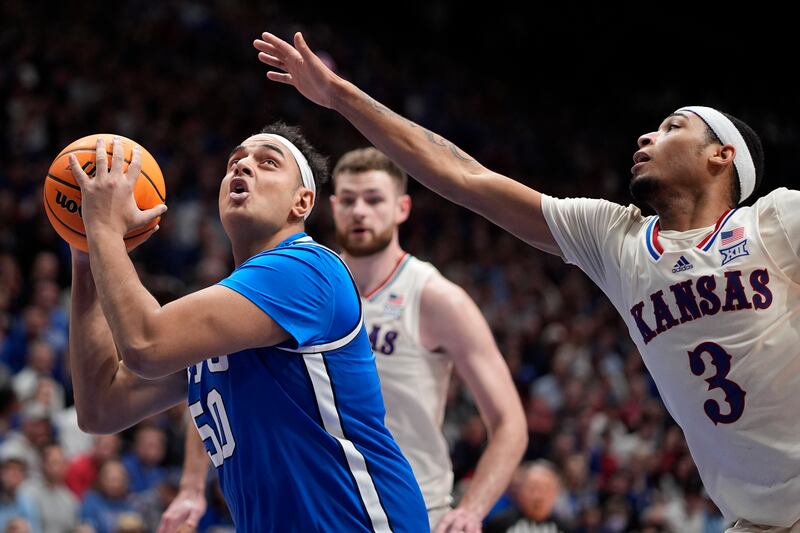 BYU center Aly Khalifa (50) looks to shoot under pressure from Kansas guard Dajuan Harris Jr. (3) during game Tuesday, Feb. 27, 2024, in Lawrence.