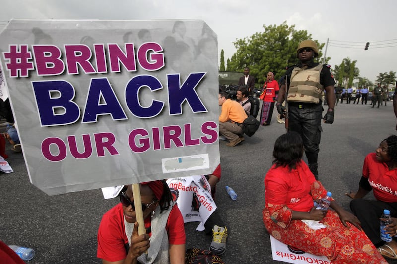 A police officer stands guard as people attend a demonstration calling on the government to rescue the kidnapped girls of the government secondary school in Chibok, in Abuja, Nigeria, Thursday, May 22, 2014. Scores of protesters chanting "Bring Back Our G
