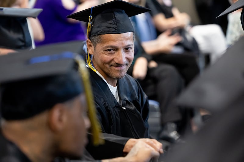 Jose Rios-Mojica gets a fist-bump from a fellow graduate at a commencement ceremony for incarcerated individuals earning their high school diploma at the Utah State Correctional Facility on June 5, 2023.
