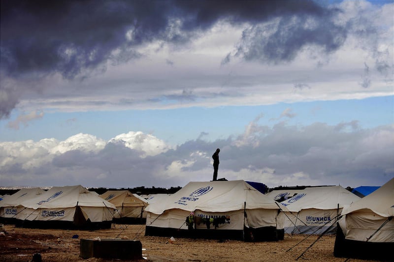 Syrian refugee stands atop a water tank at the Zaatari refugee camp, near the Syrian border in Mafraq, Jordan.
