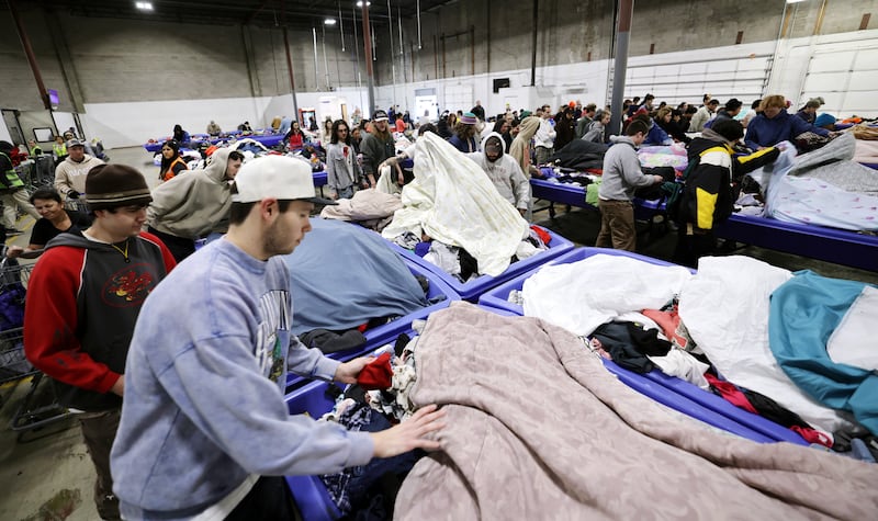Customers rush in and uncover the new products at the Goodwill Outlet in Salt Lake City on Monday, March 6, 2023.