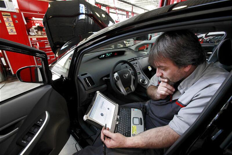 Diagnostic technician Kurt Juergens uses a laptop computer to diagnose the brake system on a Prius in Norwood, Mass.