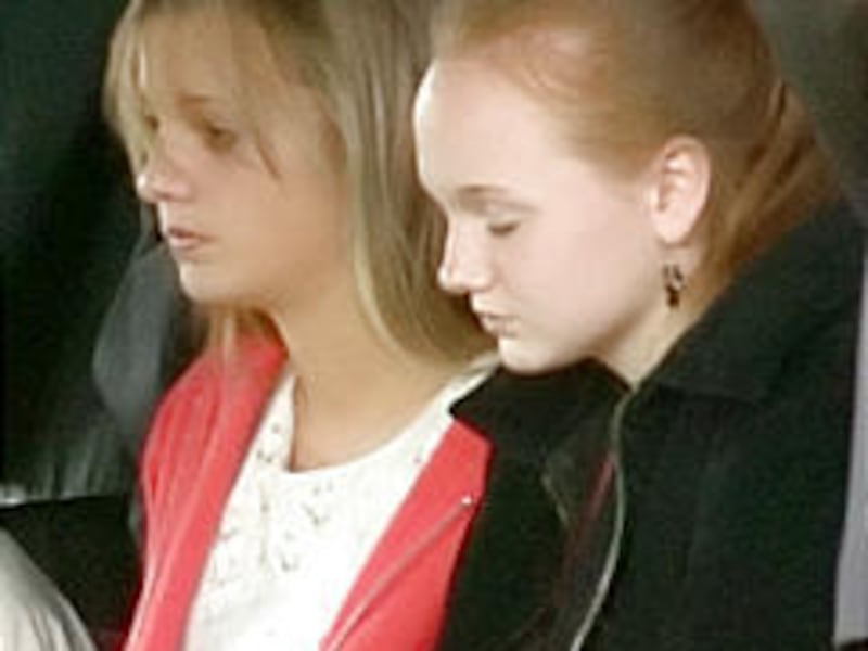 Kara Borden, left, with sister Katelyn at their parents' graveside service. Police say Kara's boyfriend killed her parents.