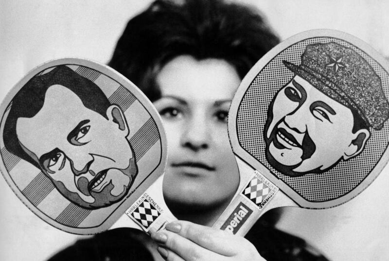 In this Friday, Nov. 5, 1971 file photo, a woman holds up Ping-Pong paddles with U.S. President Richard Nixon and Chinese Chairman Mao Zedong caricatures on them in Dortmund, Germany. Much has changed since the age of "ping pong diplomacy'' began when nin