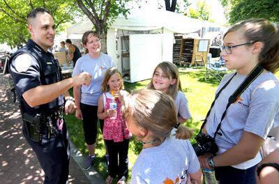 Springville Police Chief Craig Martinez talks with Kathy Shull and her children as he walks through Art City Days in Springville on Wednesday, June 5, 2019.