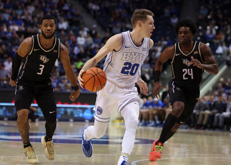 Brigham Young Cougars guard Spencer Johnson (20) drives downcourt past UCF Knights guard Darius Johnson (3) and guard Jaylin Sellers (24) at the Marriott Center in Provo on Tuesday, Feb. 13, 2024.