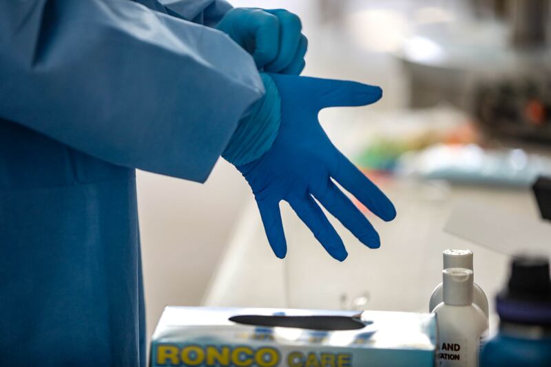 Utah National Guard Spc. Sam Sargent changes his top layer of gloves at a COVID-19 test site.
