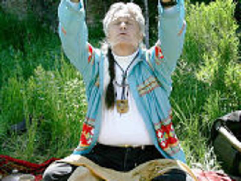 James Mooney prays over his peace pipe as he prepares to lead a small group in a ceremony in the mountains near Fountain Green in June.