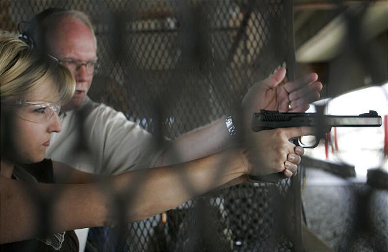 Instructor Steve Beckstead helps Brandy Vega of Channel 4 during the class at Lee Kay Shooting Range.