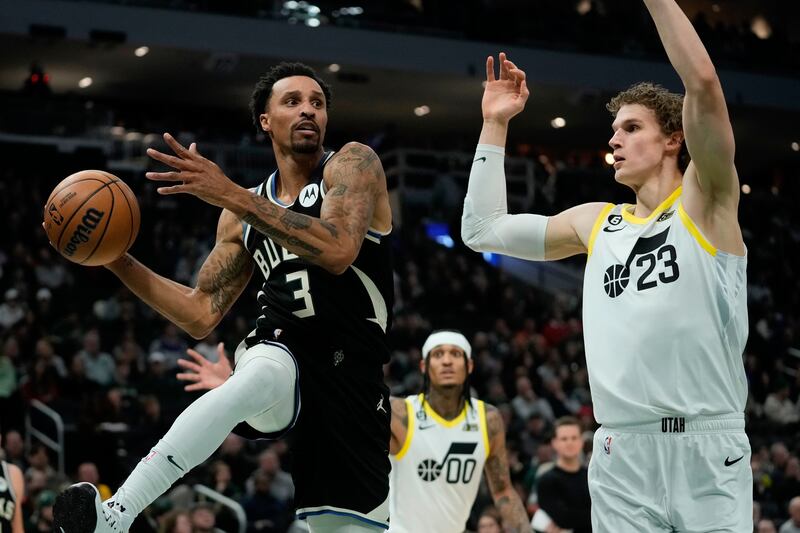Milwaukee Bucks’ George Hill passes around Utah Jazz’s Lauri Markkanen