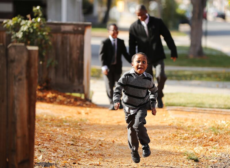 Patrick Genda, 4, runs ahead of his father Joseph and brother Norman, 10, near their home in Salt Lake City on Sunday, Nov. 18, 2018.
