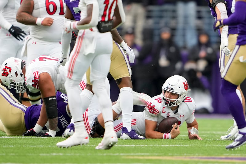 Utah quarterback Bryson Barnes (16) looks up after being tackled by Washington defensive end Bralen Trice (8) during a college football game Saturday, Nov. 11, 2023, in Seattle.