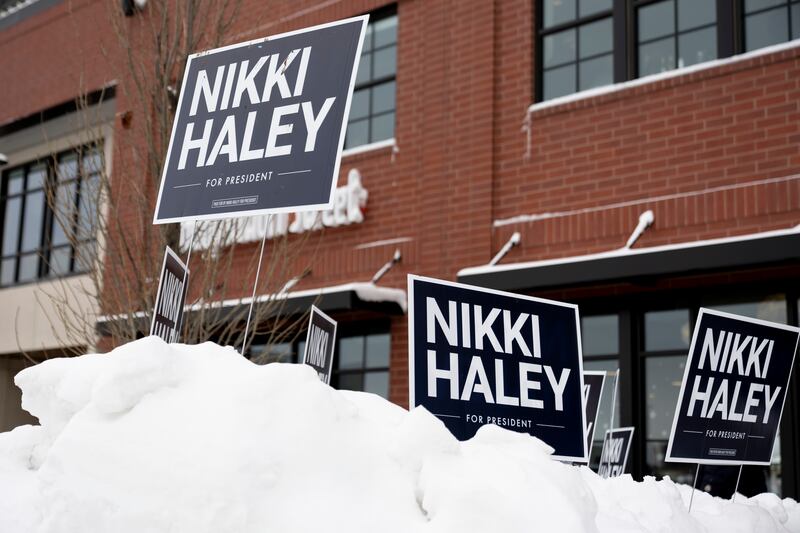 Signs are visible on a large pile of snow before Republican presidential candidate Nikki Haley speaks at Toast in Ankeny, Iowa, on Jan. 11, 2024.