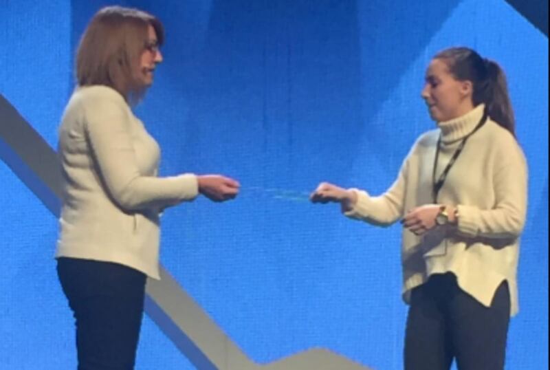 Author Liz Wiseman and audience member and BYU student Emily work with rubber bands to teach about leadership.