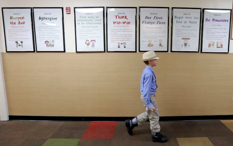 Ian Lowry walks past posters of Stephen R. Covey's "7 Habits of Highly Effective People" hanging in the hallway at Noah Webster Academy in Orem on Friday, Feb. 15, 2019. Some states are proposing that the Bible be taught in public schools — not for moral