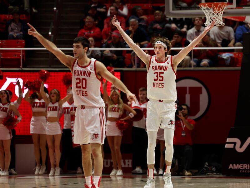 Utah Utes center Branden Carlson (35) and Lazar Stefanovic (20) celebrate at the Huntsman Center.