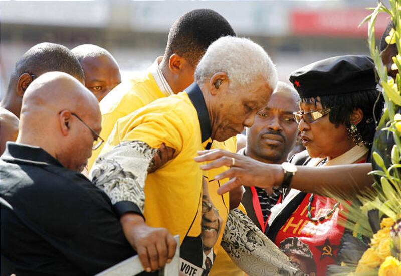 Former South African President Nelson Mandela, center, is helped up stairs at an ANC rally in Johannesburg.