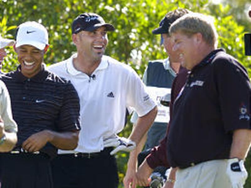 From left, Tiger Woods, Hank Kuehne and John Daly share a laugh on the third tee of the Battle At the Bridges match Monday.