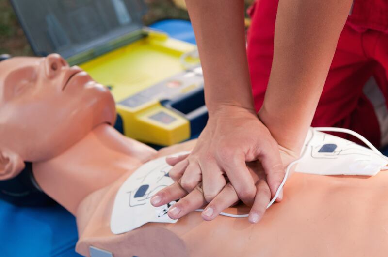 A person performs CPR on a mannequin.
